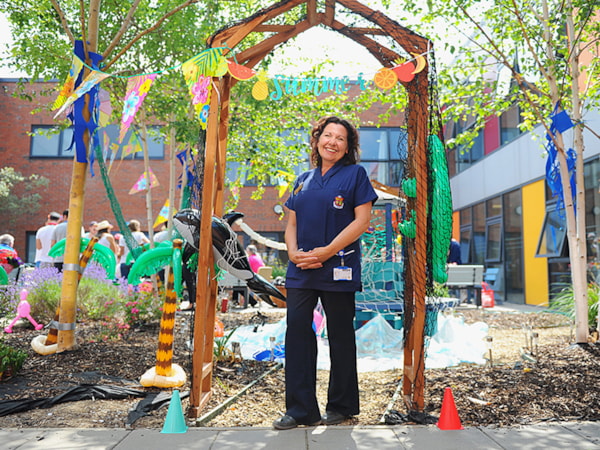 Nurse standing outside at a hospital event smiling at camera